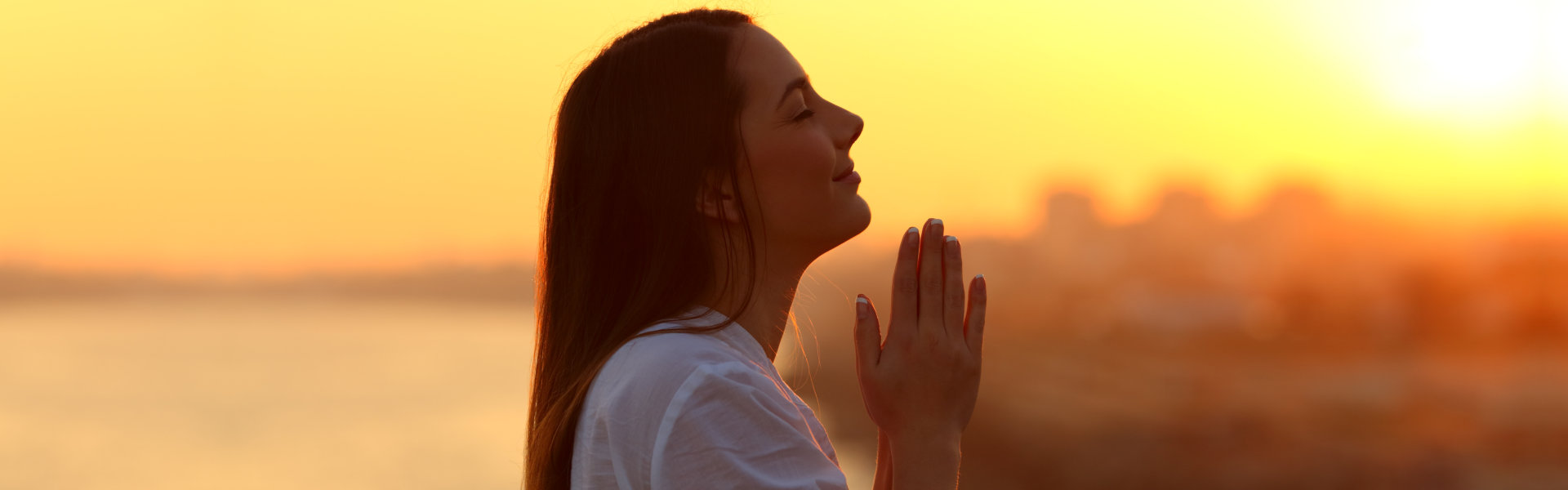 woman closing her eyes and praying