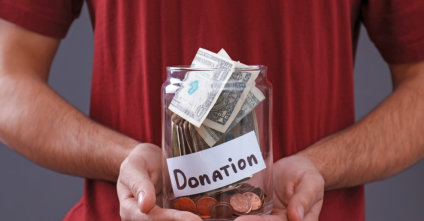 man holding a donation glass