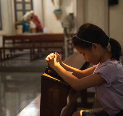 a kid focus on her prayer